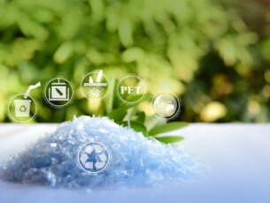 A Pile of PET bottle flakes with green tree blur background.